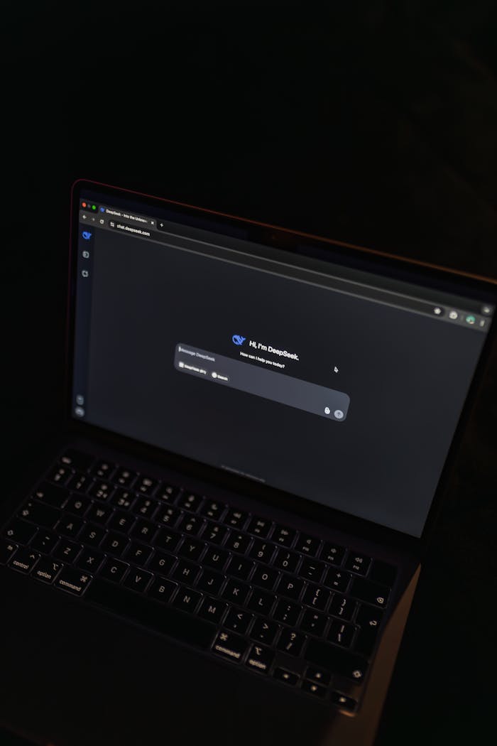 A MacBook displaying an AI chat interface in a dimly lit setting, showcasing modern technology.